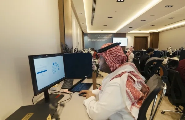 متخصص مشتريات يعمل على شاشتين في مركز العمليات
